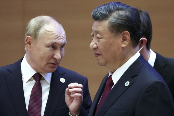 Russian President Vladimir Putin, left, gestures while speaking to Chinese President Xi Jinping during the Shanghai Cooperation Organization (SCO) summit in Samarkand, Uzbekistan, Friday, Sept. 16, 20 ...