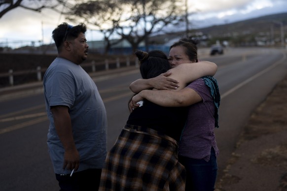 Nora Bulosan, right, and Hannah Tomas, Lahaina, Hawaii residents who survived the fire that devastated the town, comfort each other as they gather in hopes to get access to their home in Lahaina, Hawa ...