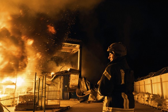 03.02.2023, Ukraine, Cherson: Feuerwehrleute des staatlichen ukrainischen Katastrophenschutzes löschen ein Feuer, nachdem russischer Granatenbeschuss ein Einkaufszentrum getroffen hat. Foto: Libkos/AP ...