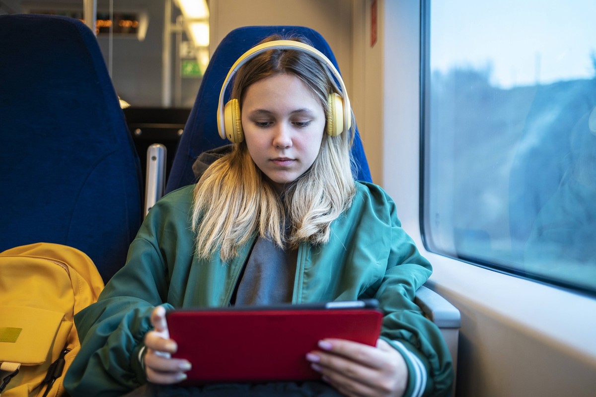 Teenage blond girl using tablet PC sitting in train model released, Symbolfoto, MDOF01938