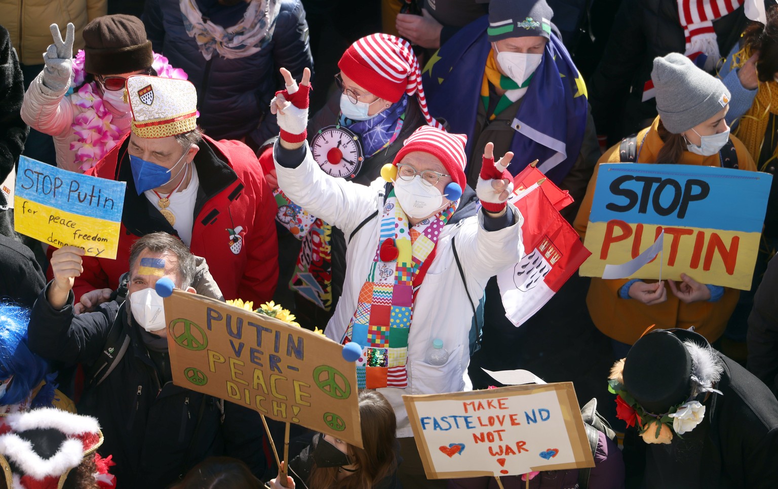 28.02.2022, Nordrhein-Westfalen, K�ln: Teilnehmer der Friedensdemonstration am Rosenmontag halten Plakate mit der Aufschrift &quot;Stop Putin&quot;. Nach dem russischen Angriff auf die Ukraine wurde d ...