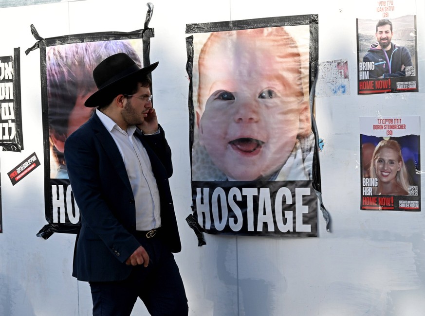 An Orthodox Jew looks at a poster of a baby hostage being held in captivity by Hamas in Gaza, at a protest outside the Knesset, the Parliament, in Jerusalem, on Monday, November 6, 2023. PUBLICATIONxI ...