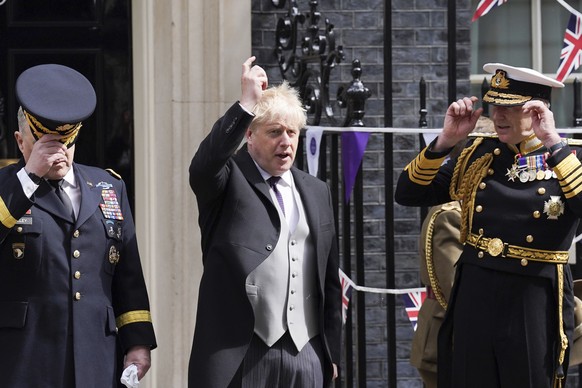 British Prime Minister Boris Johnson poses for a photograph with military personnel outside 10 Downing Street, London, Thursday, June 2022 on the first of four days of celebrations to mark the Platinu ...