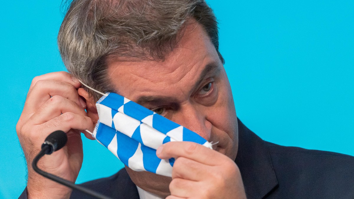 ARCHIV - 27.07.2020, Bayern, München: Markus Söder (CSU), Ministerpräsident von Bayern, setzt sich nach einer Pressekonferenz zur Corona-Lage in Mamming seine Mundschutzmaske auf. (zu "Söder sagt ...