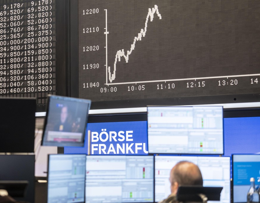 Ein Händler sitzt im Handelssaal der Frankfurter Börse vor der Dax-Kurve und seinen Monitoren, auf denen auch Berichte über die US-Präsidentschaftswahl laufen. +++ dpa-Bildfunk