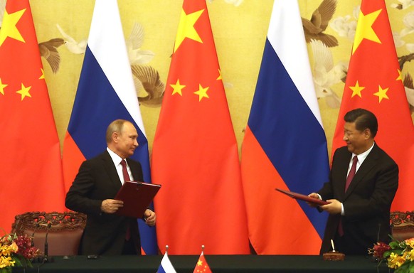 Russian President Vladimir Putin (L) and Chinese President Xi Jinping exchange trade agreements at a signing ceremony in Beijing on June 8, 2018. Russian trade and cooperation with China has reached a ...