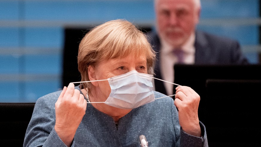 German Chancellor Angela Merkel removes her face mask before the National Integration Prize honoring engagement for integration in Berlin, October 5, 2020. Kay Nietfeld/Pool via REUTERS