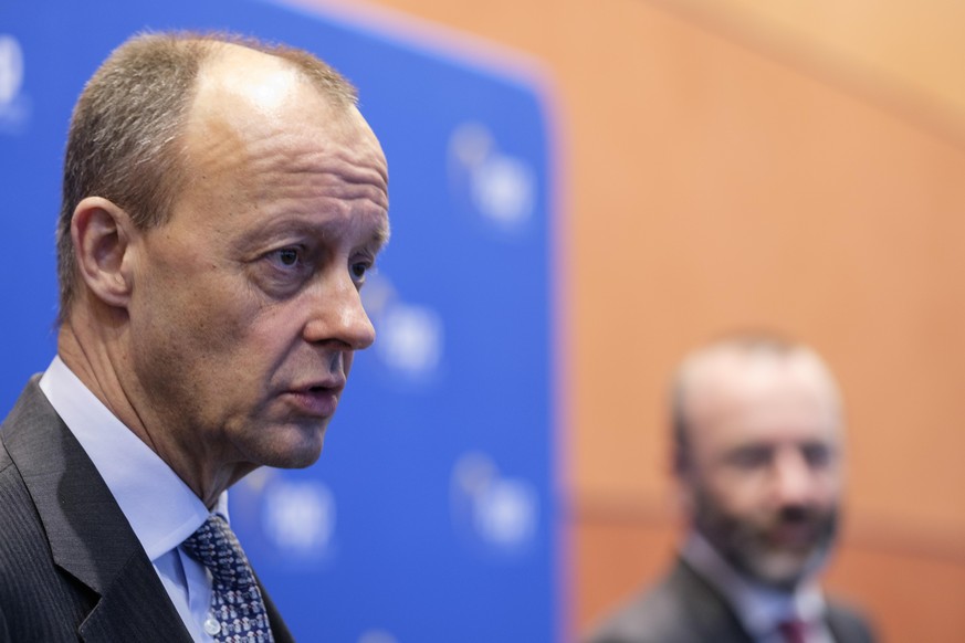 Leader of the Christian Democratic Union (CDU) Friedrich Merz (L) is welcome by the Leader of the European People&#039;s Party in the European Parliament Manfred Weber (R) prior a debate with the Memb ...