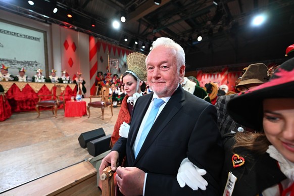 16.02.2023, Baden-Württemberg, Stockach: Der stellvertretende Bundestagspräsident Wolfgang Kubicki (FDP) wird statt von Laufnarren am Band von zwei Frauen in den Saal geführt. Das Narrengericht in Sto ...