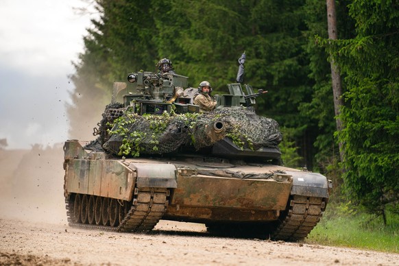 ARCHIV - 08.06.2022, Bayern, Hohenfels: Ein Panzer des Typs M1 Abrams der US Army fährt während einer multinationalen Übung auf dem Truppenübungsplatz Hohenfels über eine Straße. (zu dpa &quot;Leopard ...