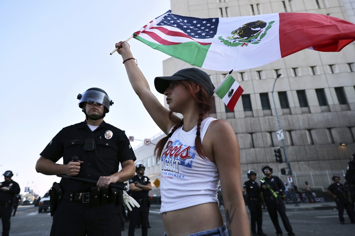 10.06.2025, USA, Los Angeles: Demonstranten versammeln sich während einer Demonstration als Reaktion auf eine Reihe von Razzien der US-amerikanischen Einwanderungs- und Zollbehörde (ICE) im ganzen Lan ...