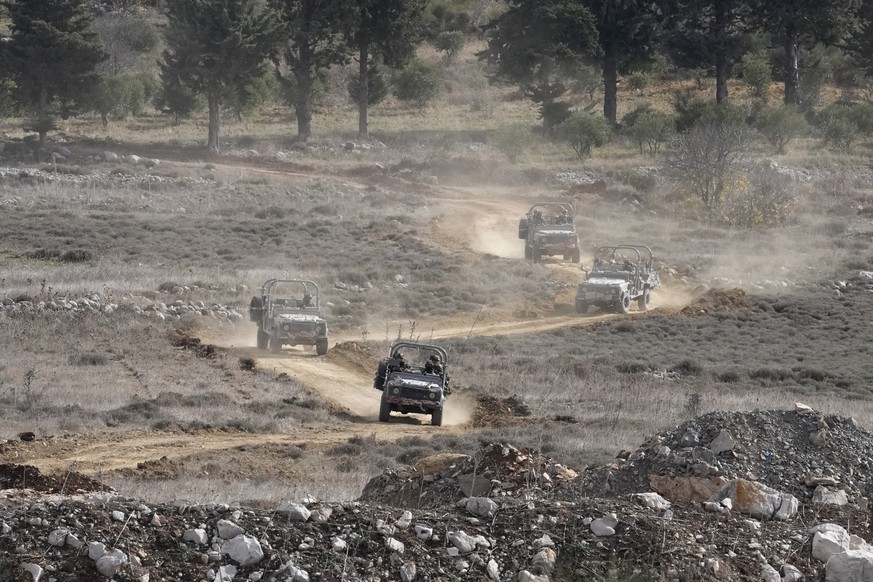 Israeli armoured vehicles maneuver next to the security fence near the so-called Alpha Line that separates the Israeli-annexed Golan Heights from Syria, in the town of Majdal Shams, Wednesday, Dec. 11 ...