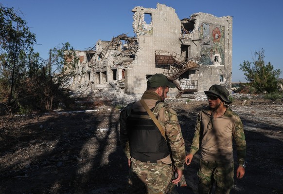 KHERSON REGION, UKRAINE - JULY 23, 2022: Servicemen are seen outside a destroyed school building in the village of Oleksandrivka. The Russian Armed Forces are carrying out a special military operation ...