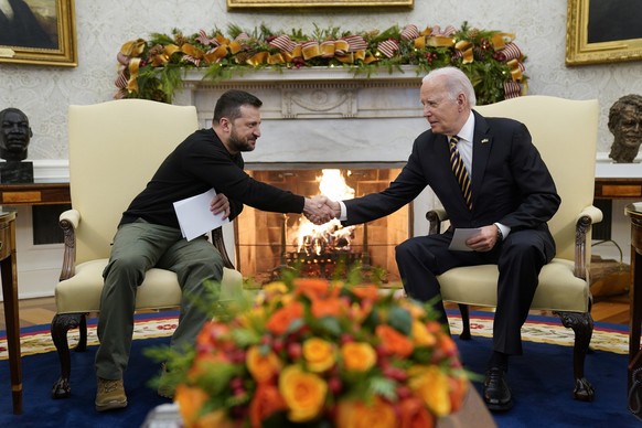 12.12.2023, USA, Washington: Joe Biden (r), Präsident der USA, schüttelt Wolodymyr Selenskyj, Präsident der Ukraine, die Hand, während sie sich im Oval Office des Weißen Hauses treffen. Mit Blick auf  ...