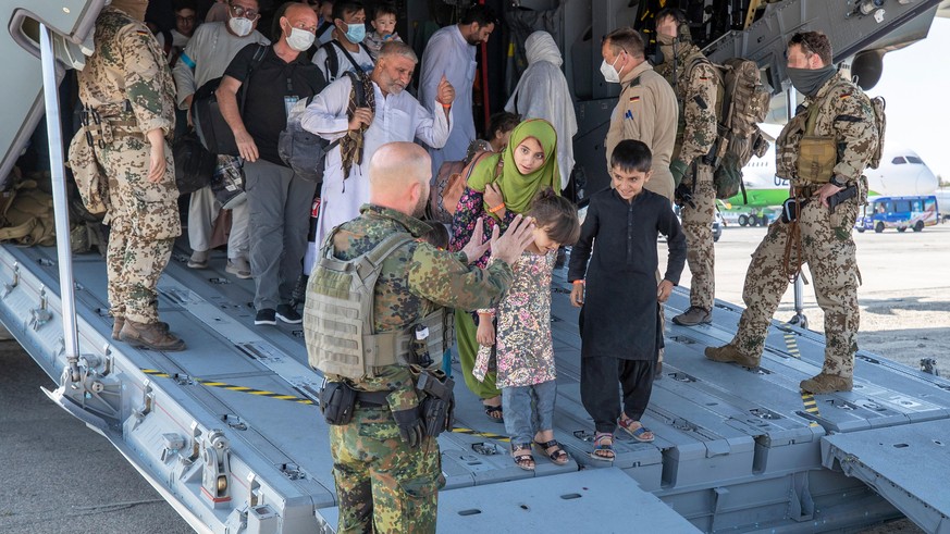 dpatopbilder - HANDOUT - 18.08.2021, Usbekistan, Taschkent: Kurz nach der Landung werden die Evakuierten von deutschen Sicherungskräften aus dem Airbus A400M geleitet. Nach der Machtübernahme der Tali ...