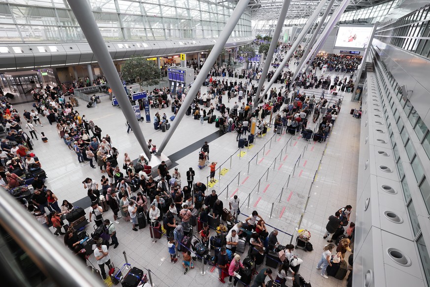 Lange Warteschlangen im Düsseldorfer Flughafen. Menschen stehen der Warteschlange, um das Gepäck abzugeben . (zu dpa: «Koffer-Chaos am Düsseldorfer Flughafen»)