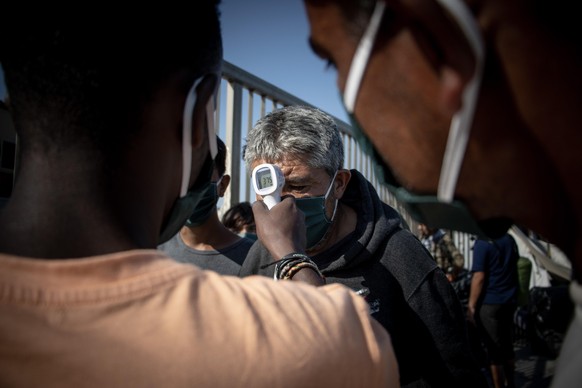Asylum seekers have their body temperature checked by a handheld thermometer before entering the Humanitarian Aid facility from Team Humanity Denmark. The NGO helps the refugees and migrants after the ...