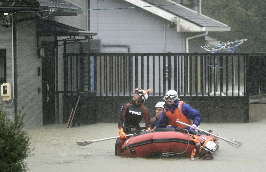 Rettungskräfte sitzen auf einem Boot in einem überfluteten Wohngebiet der Präfektur Mie.