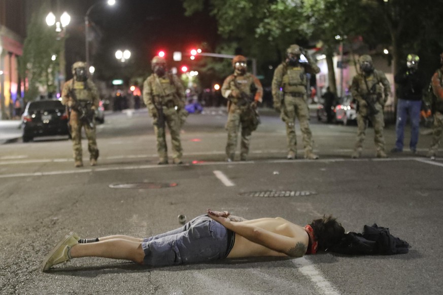 26.07.2020, USA, Portland: Ein Demonstrant liegt während eines «Black Lives Matter»-Protests vor dem Bundesgericht Mark O. Hatfield auf der Straße. In den USA reißen die Proteste gegen Polizeigewalt u ...