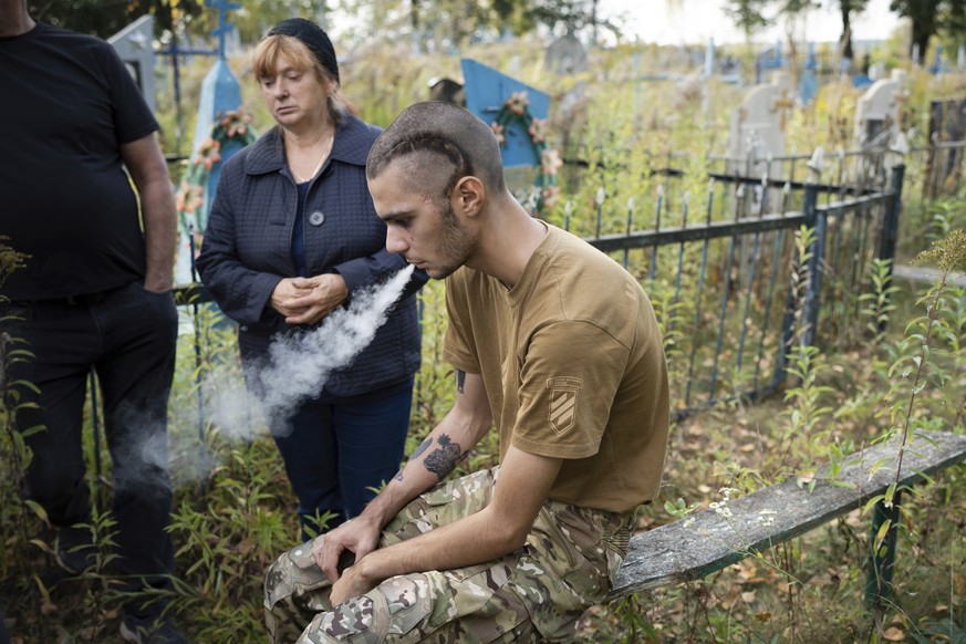 dpatopbilder - 26.09.2023, Ukraine, Schostka: Der ukrainische Soldat Pavlo &quot;Zhulik&quot; Sazonov raucht eine Zigarette nach der Beerdigung seines Kameraden Andrii &quot;Adam&quot; Grinchenko von  ...