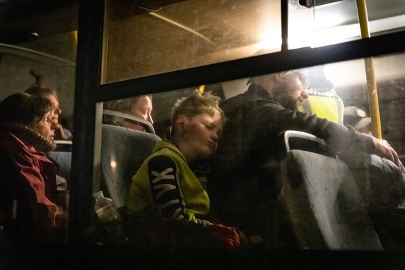 May 8, 2022, Zaporizhia, Zaporizika Oblast, Ukraine: A boy sleeps by his father as they evacuate from Mariupols Azovstal to Zaporizhia on Sunday night. United Nations and The Red Cross has now evacuat ...