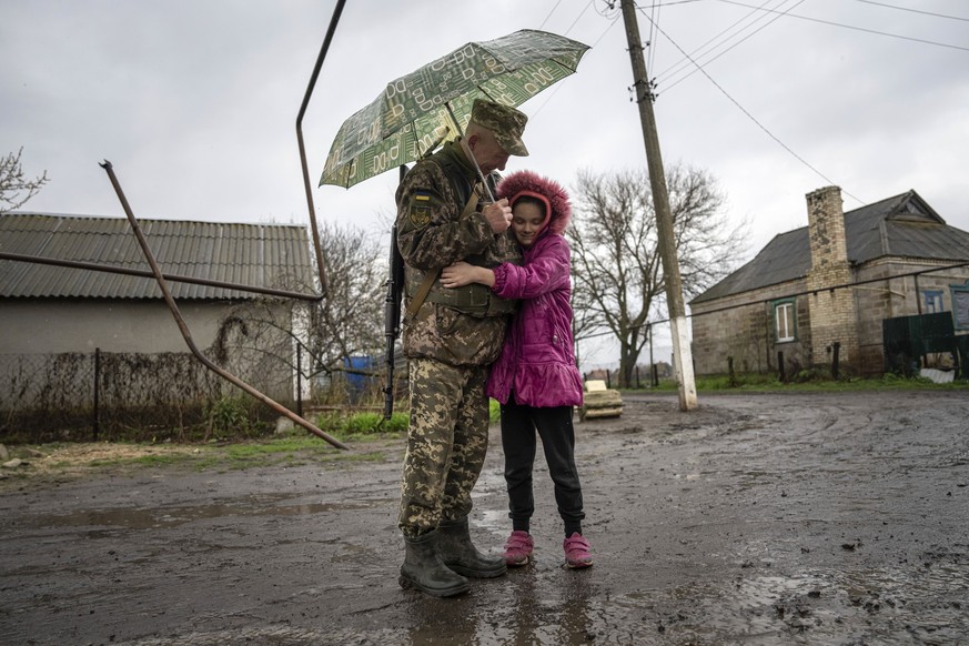 09.04.2023, Ukraine, Bohojawlenka: Die 10-jährige Khrystyna umarmt einen ukrainischen Soldaten der Jagdbrigade 68 Oleksa Dovbush. Ihr Vater starb an den Folgen einer Verletzung, nachdem eine Granate i ...