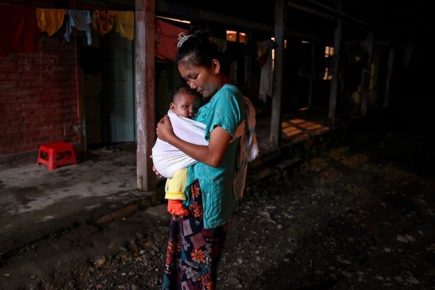 In this picture taken on July 25, 2023, a woman carries her child at a relief camp for displaced tribals in Churachandpur. Deadly ethnic violence in India&#039;s troubled Manipur state divided communi ...
