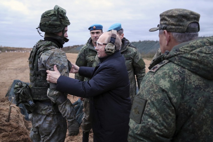 ARCHIV - 20.10.2022, Russland, Rjasan: Dieses von der staatlichen russischen Nachrichtenagentur Sputnik via AP veröffentlichte Foto zeigt Wladimir Putin (M), Präsident von Russland, im Gespräch mit ei ...