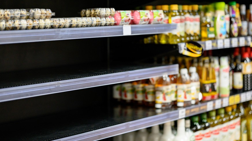 Empty egg shelves in a grocery store or supermarket. Hoarding food due to Coronavirus outbreak. Prepare food supplies for the worst case of COVID-19 pandemic. Stockpiling crisis all around the world.