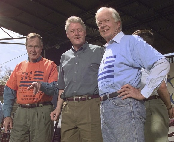 FILE - Former Presidents George Bush, left, and Jimmy Carter, right, stand with President Clinton during a kick-off rally for the President&#039;s volunteer summit at Marcus Foster Stadium in Philadel ...