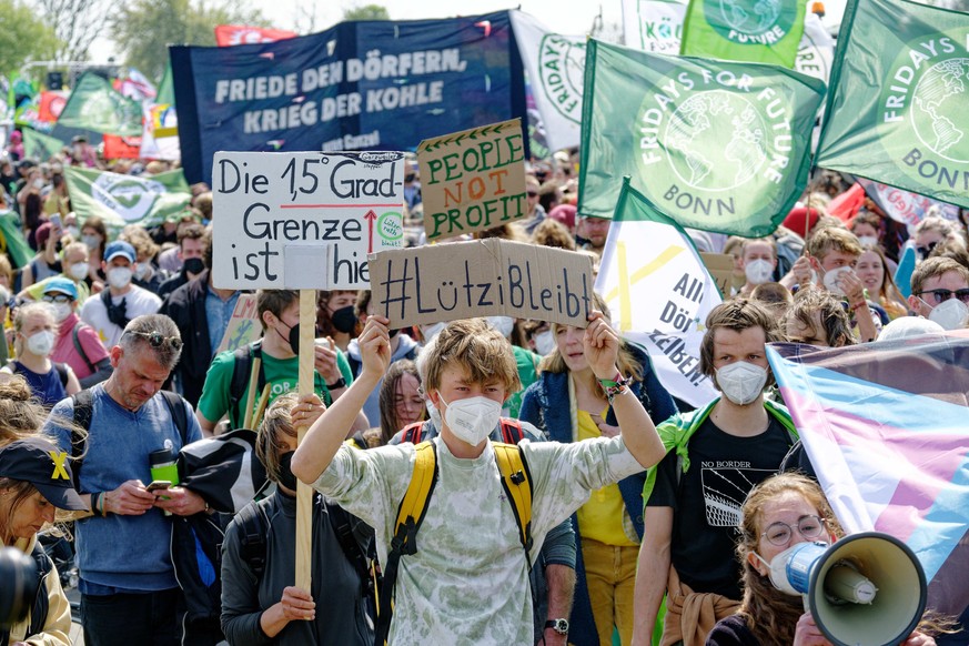 Teilnehmer einer Demonstration gehen auf einer Strasse in Richtung von Lützerath. &quot;Fridays for Future&quot;, &quot;Alle Dörfer Bleiben&quot; und andere Gruppen hatten zu der Kundgebung zum Schutz ...