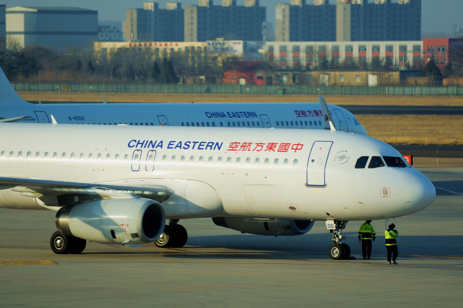 QINGDAO, CHINA - FEBRUARY 21, 2021 - Ground staff check a China Eastern Airlines passenger plane before it takes off at the Liuting Airport in Qingdao, Shandong province, China, Feb 21, 2021.