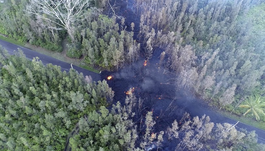 In this still frame taken from video, lava flows over a road in the Puna District as a result of the eruption from Kilauea Volcano on Hawaii's Big Island Friday, May 4, 2018. The eruption sent molten  ...