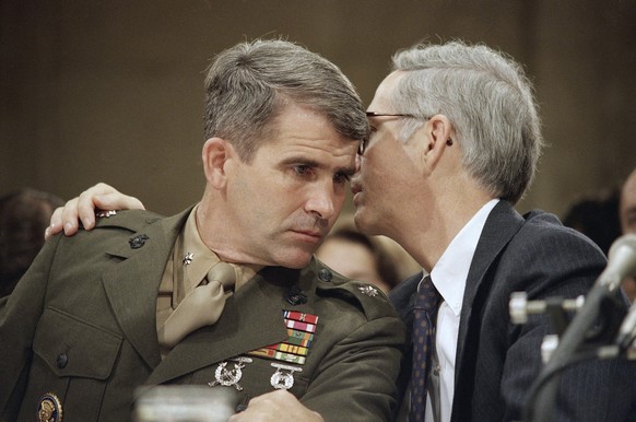 FILE - Lt. Col. Oliver North gets advise from his attorney Brendan Sullivan, right, while testifying before the joint House-Senate committee investigating the Iran-Contra affair on Capitol Hill, Washi ...