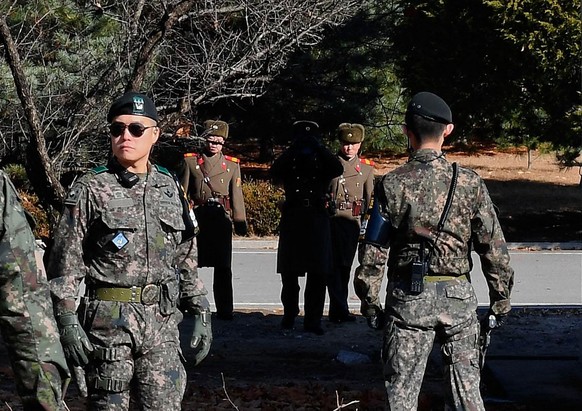 PANMUNJOM, SOUTH KOREA - NOVEMBER 27: (SOUTH KOREA OUT) North Korean soldiers look at South at a spot where a North Korean defected crossing the border as South Korean Defense Minister Song Young-moo  ...