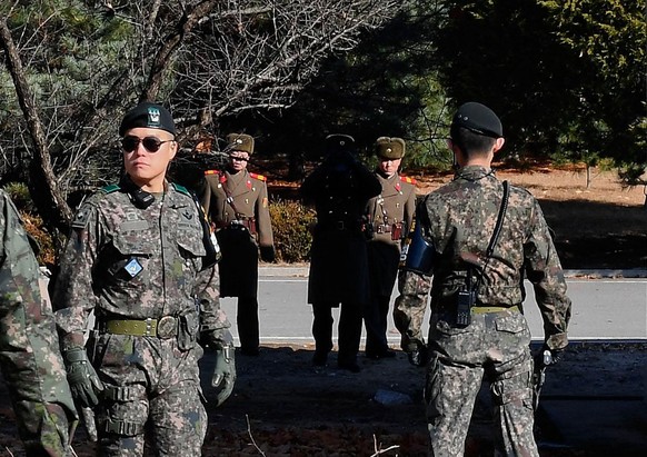 PANMUNJOM, SOUTH KOREA - NOVEMBER 27: (SOUTH KOREA OUT) North Korean soldiers look at South at a spot where a North Korean defected crossing the border as South Korean Defense Minister Song Young-moo ...