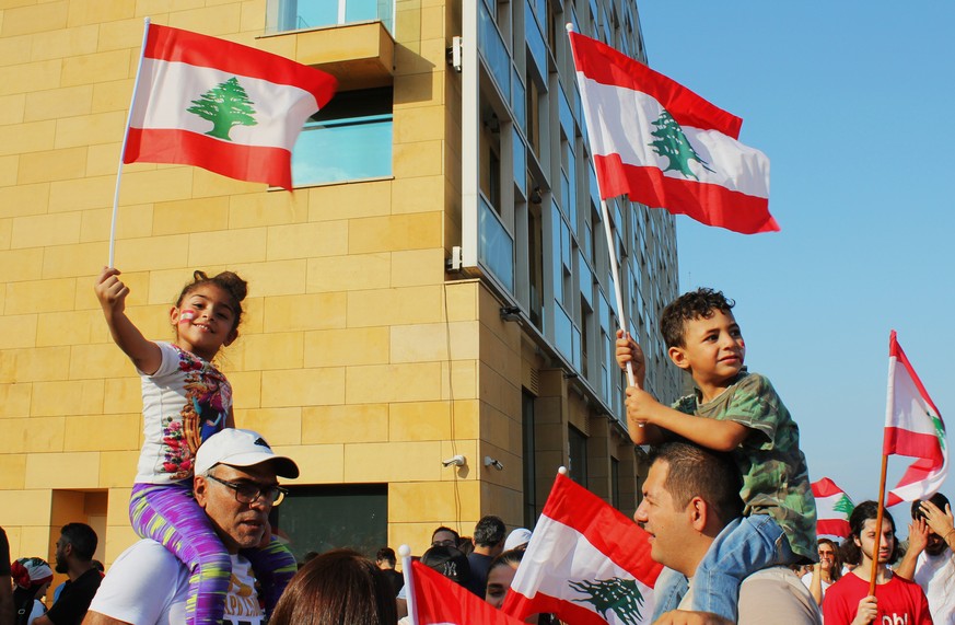 Kinder schwenken die libanesische Fahne mit der Zeder.