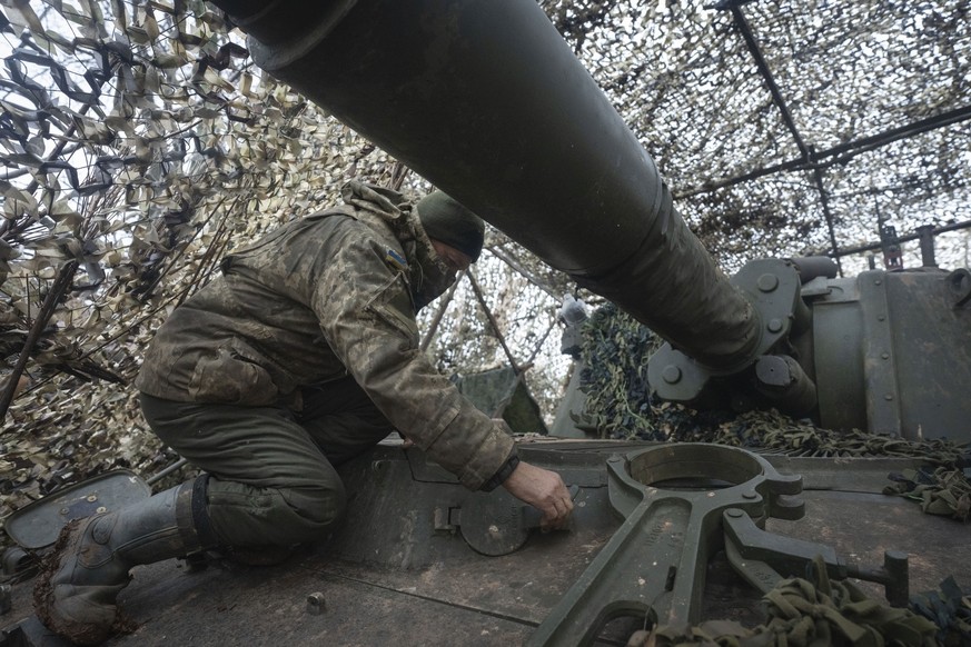 28.01.2024, Ukraine, Kreminna: Ein Soldat der 12. Asow-Brigade der Nationalgarde bereitet eine 155-mm-Panzerfaust M109 Paladin für den Abschuss auf russische Stellungen an der Frontlinie in der Nähe v ...