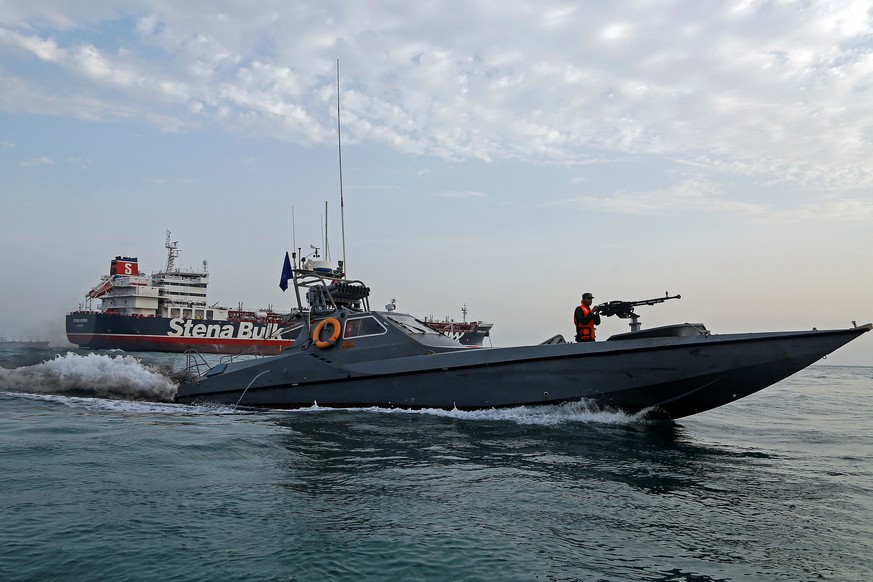 A boat of the Iranian Revolutionary Guard sails next to Stena Impero, a British-flagged vessel owned by Stena Bulk, at Bandar Abbas port, July 21, 2019. Picture taken July 21, 2019. Iran, Mizan News A ...