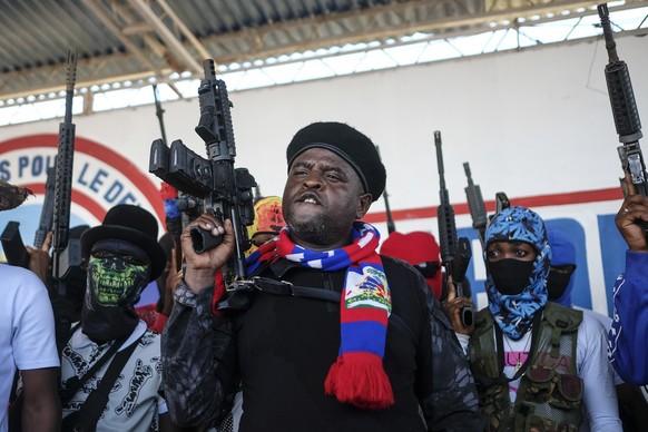 FILE - Leader of the "G9 and Family" gang, Jimmy Cherizier, better known as Barbecue, shouts slogans with his gang members after giving a speech, as he leads a march against kidnappings, thr ...