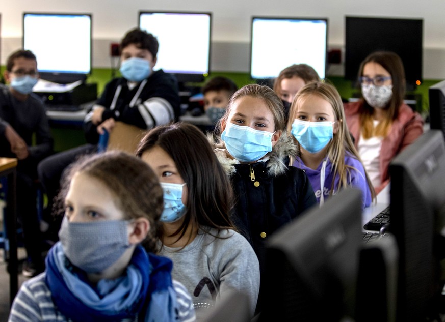 FILE - In this Oct.21, 2020 file photo pupils of a fifth class at a high school wear face masks as they take part in an electronic learning session in Frankfurt, Germany. Amid pressure to relax the lo ...