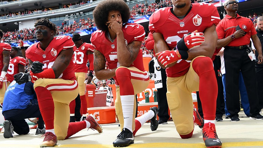 SANTA CLARA, CA - OCTOBER 02: (L-R) Eli Harold #58, Colin Kaepernick #7 and Eric Reid #35 of the San Francisco 49ers kneel on the sideline during the anthem prior to the game against the Dallas Cowboy ...