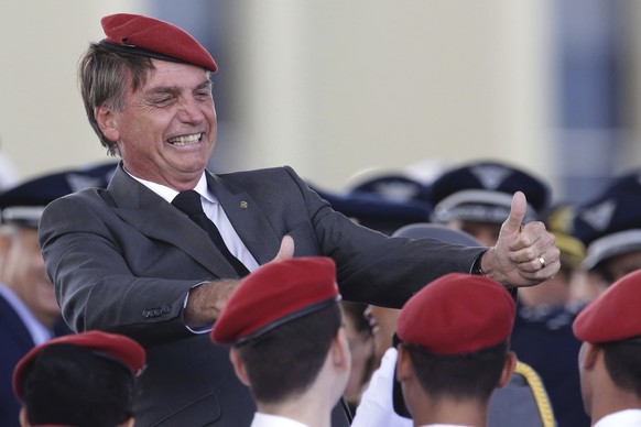 FILE - In this April 19, 2018 file photo, presidential hopeful, conservative Brazilian lawmaker Jair Bolsonaro flashes two thumbs up as he poses for a photo with cadets during a ceremony marking Army ...