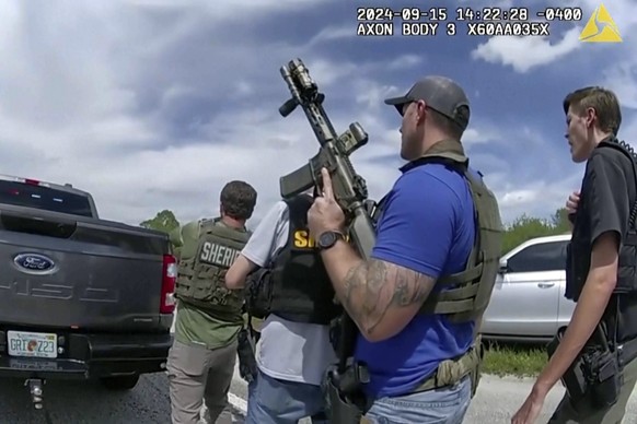 In this image taken from police body camera video and released by the Martin County, Fla., Sheriff’s Office, law enforcement officers prepare to arrest Ryan Routh, the man suspected in the apparent as ...