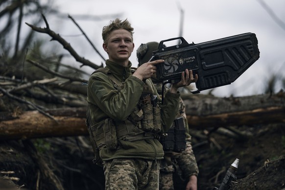 28.04.2023, Ukraine, Awdijiwka: Ein ukrainischer Soldat setzt ein Drohnenabwehrgeschütz gegen eine russische Drohne ein, während er in einem Schützengraben in der Nähe von Awdijiwka in der Region Done ...