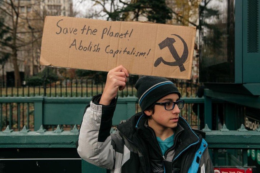 NEW YORK, NY - DECEMBER 06: A boy holds a sign at a youth-led climate strike organized by environmental groups including Extinction Rebellion and Sunrise Movement near City Hall on December 6, 2019 in ...