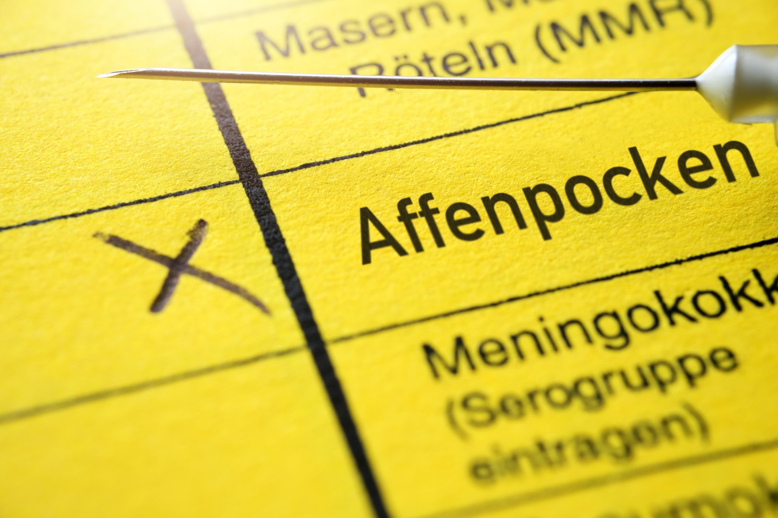 Impfausweis mit Schriftzug Affenpocken und Impfspritze, Impfstoff gegen Affenpocken