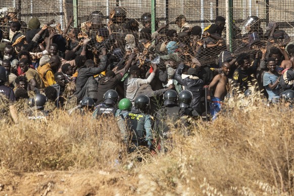ARCHIV - 24.06.2022, Spanien, Melilla: Migranten kommen auf spanischem Boden an, nachdem sie die Z�une zwischen der spanischen Exklave Melilla und Marokko �berquert haben. Spaniens Innenminister Grand ...