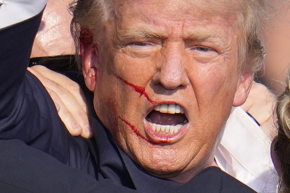 13.07.2024, USA, Butler: Der ehemalige US-Präsident Donald Trump reagiert nach einem Attentat auf einer Wahlkampfveranstaltung. Foto: Gene J. Puskar/AP +++ dpa-Bildfunk +++