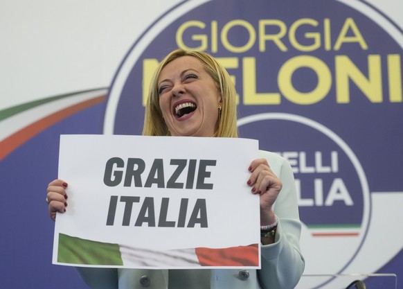 Far-Right party Brothers of Italy's leader Giorgia Meloni shows a placard reading in Italian "Thank you Italy" at her party's electoral headquarters in Rome, Monday, Sept. 26, 2022 ...